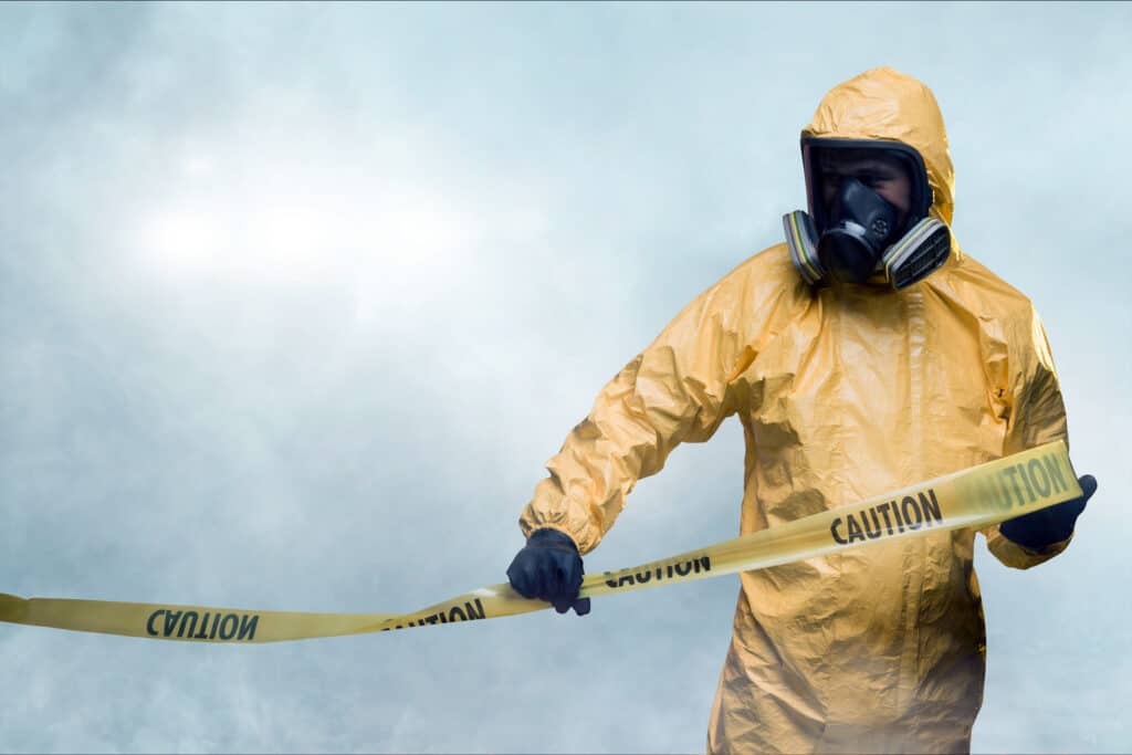 biohazard cleanup being circled with yellow caution tape by a disaster restoration expert